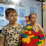 dziewczynka i chłopiec prezentują zbudowany z klocków przez siebie zamek