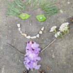 praca uczniów przedstawiająca ludzika wykonanego z szyszek kwiatków, patyczków i trawy