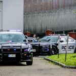 dwa samochody amerykańskiej policji przyjeżdża pod budynek szpitala
