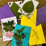 siedem prac plastycznych z przyklejonymi naturalnymi kwiatkami i listkami