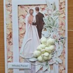 kartka okolicznościowa z okazji ślubu wykonana techniką scrapbookingu z bukietem kwiatów z parą młodą odwróconą plecami