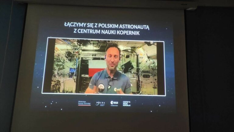 Zdjęcie przedstawia ekran, na którym wyświetlone jest połączenie on-line z astronautą Sławoszem Uznańskim-Wiśniewskim.
