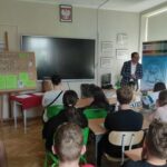 Na zdjęciu II wicewojewoda z uczniami w sali lekcyjnej rozmawiający o edukacji obywatelskiej.