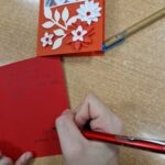 uczennica długopisem podpisuje się na kartce z życzeniami dla powstańców