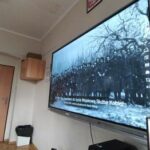 na ekranie telewizora widać urywek filmu o powstaniu warszawskim