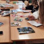 Uczniowie wypisują w języku niemieckim przygotowane kartki świąteczne