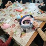 Dwie pensjonariuszki domu pomocy społecznej uruchamiają młynek dziewiarski