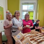 trzy panie prezentują otrzymane od uczniów upominki