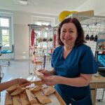 kobieta w granatowym mundurku trzyma w ręce upominek otrzymany od uczennic