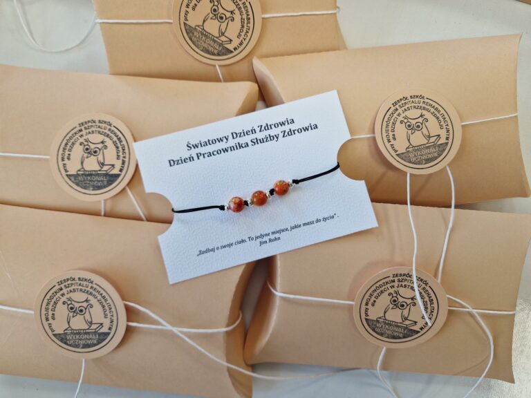 zdjęcia przedstawia bransoletkę wyplecioną z czarnego sznurka z trzema czerwonymi koralikami