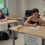 uczniowie przy stolikach rozwiązują zadania konkursowe