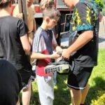 Strażak zapoznaje uczniów z wyposażeniem wozu strażackiego.