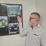Bartosz Lipski pokazuje swoją pracę konkursową w gablocie