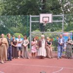 nauczyciele stoją na boisku szkolnym